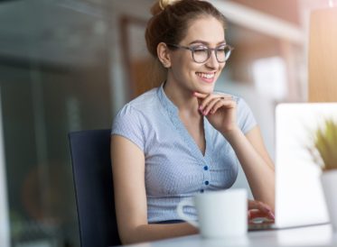 Young business woman working on laptop in office