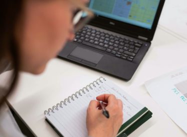 Woman writing in a notebook at a desk