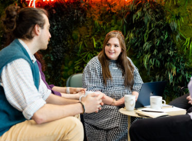 Sustainit team talking in an office with plants