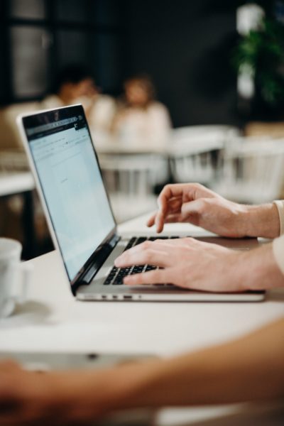 Hands typing on a laptop at a desk.