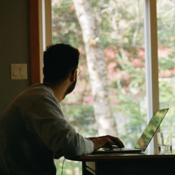 Man working from home looking out the window.