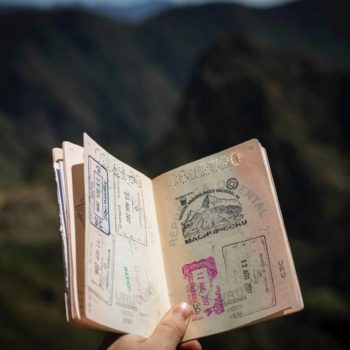 Passport being held open with a mountainous background